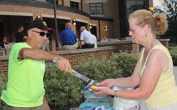 Manny Pacheco serves up a "dog" to Jacki Hunneycutt at the Wecome Barbecue.