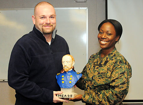 Gunnery Sgt. Katesha Washington, NCOIC of DINFOS' Public Affairs Leadership Department (PALD), presented the coveted "Georgie" to former Marine CC Will Skelton during this morning's weekly faculty meeting. Skelton, an instructor assigned to PALD's core curriculum team, received the Gen. George Meade bust for his "steadfast devotion to duty and infectious positive attitude." It shall be Skelton's chore next week to select and honor a faculty colleague with the department's unique spirit award. (Photo by Rick Corral).