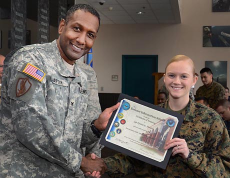 Col. Jeremy M. Martin, Commandant of the Defense Information School, presents Marine Sgt. Kristin Moreno with her certificate of completion during the graduation ceremony for the Intermediate Public Affairs Specialist Course 020-13, held in the DINFOS Hall of Heroes, Feb. 1. Moreno, along with her 20 classmates, received advanced instruction in communications planning, crisis communication, media operations, and public affairs deployment operations and planning. Photo by Matthew Williams, instructor, Public Affairs Department, Defense Information School
