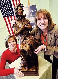 Marietta, Ga. Kiwanis Club members, Sally Macaulay, left, and CC Victoria Turney place a smaller-scale copy of a statue called ‘Forever Remember’ to honor the families of Americas heroes at the Marietta-Cobb Museum of Art. Macaulay, the museum’s executive director, and Turney, president of the Kiwanis Club of Marietta, are part of a club project to put a full-size version of the statue in a park on Roswell Street in downtown Marietta. (Photo by Staff/Mike Jacoby)